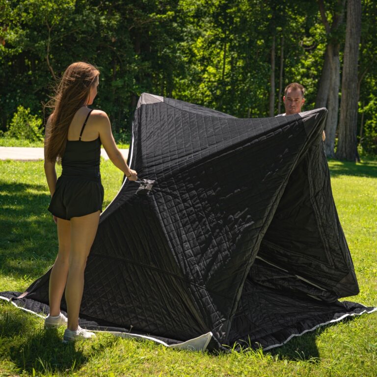 Person setting up SaunaTrekker sauna tent